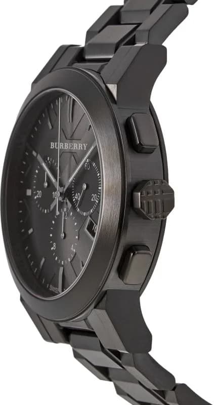Visage cadran Burberry BU9354 dévoile index bâtons appliqués, aiguilles facettées et guichet date encadré de blanc sur fond noir soleillé