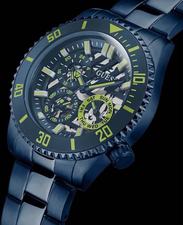 Visage cadran Guess GW0488G4 avec index appliques bâtons et aiguilles squelettées sur fond bleu translucide