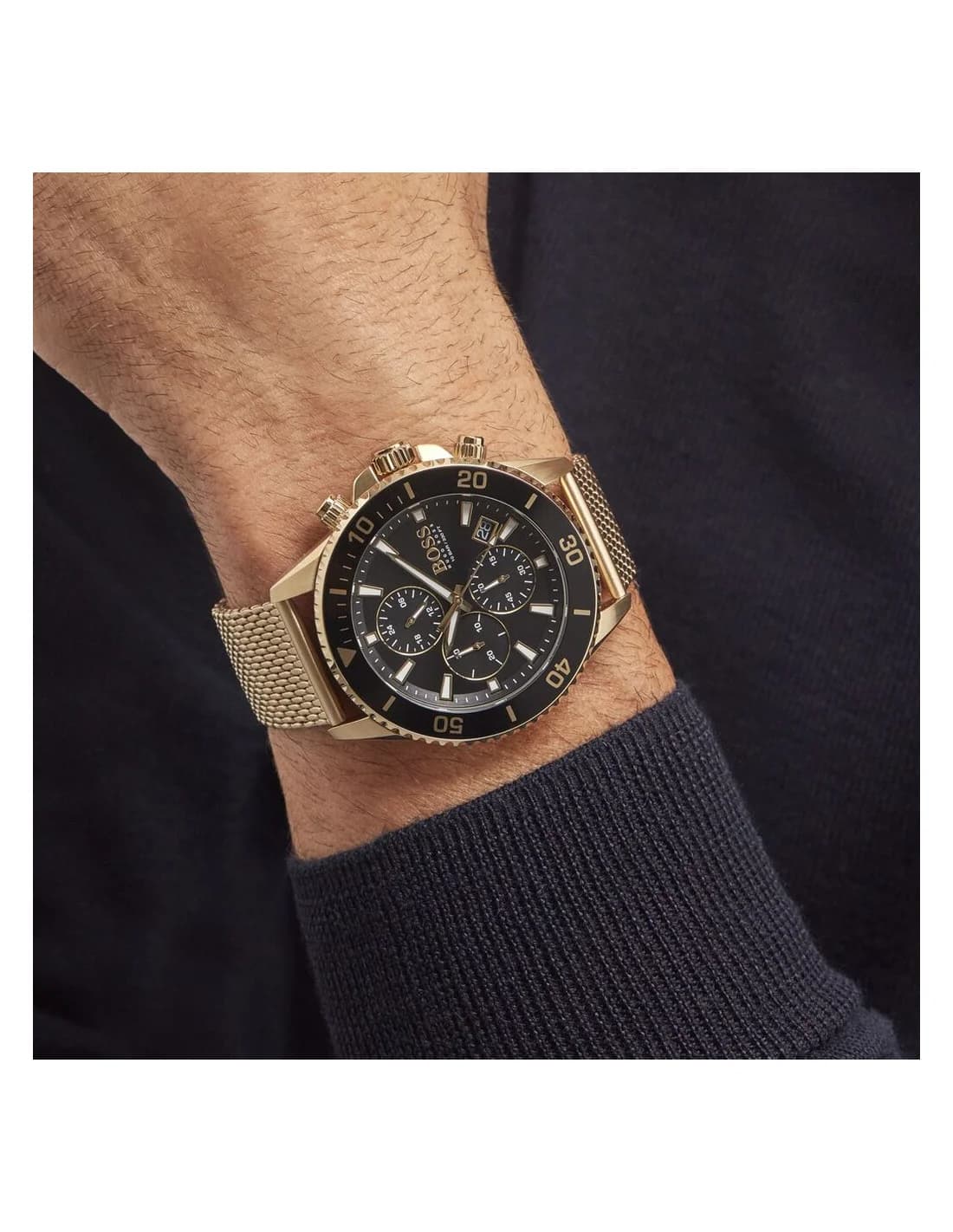 Visage cadran Hugo Boss 1513906 avec compteurs chronographe noirs cerclés d'or et guichet date à 4h30 sur fond noir soleillé