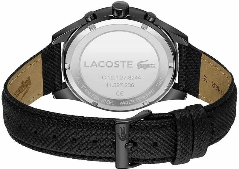 Visage cadran Lacoste 2011296 avec guichet date à 4h30 et sous-cadrans multifonctions sur fond noir texturé