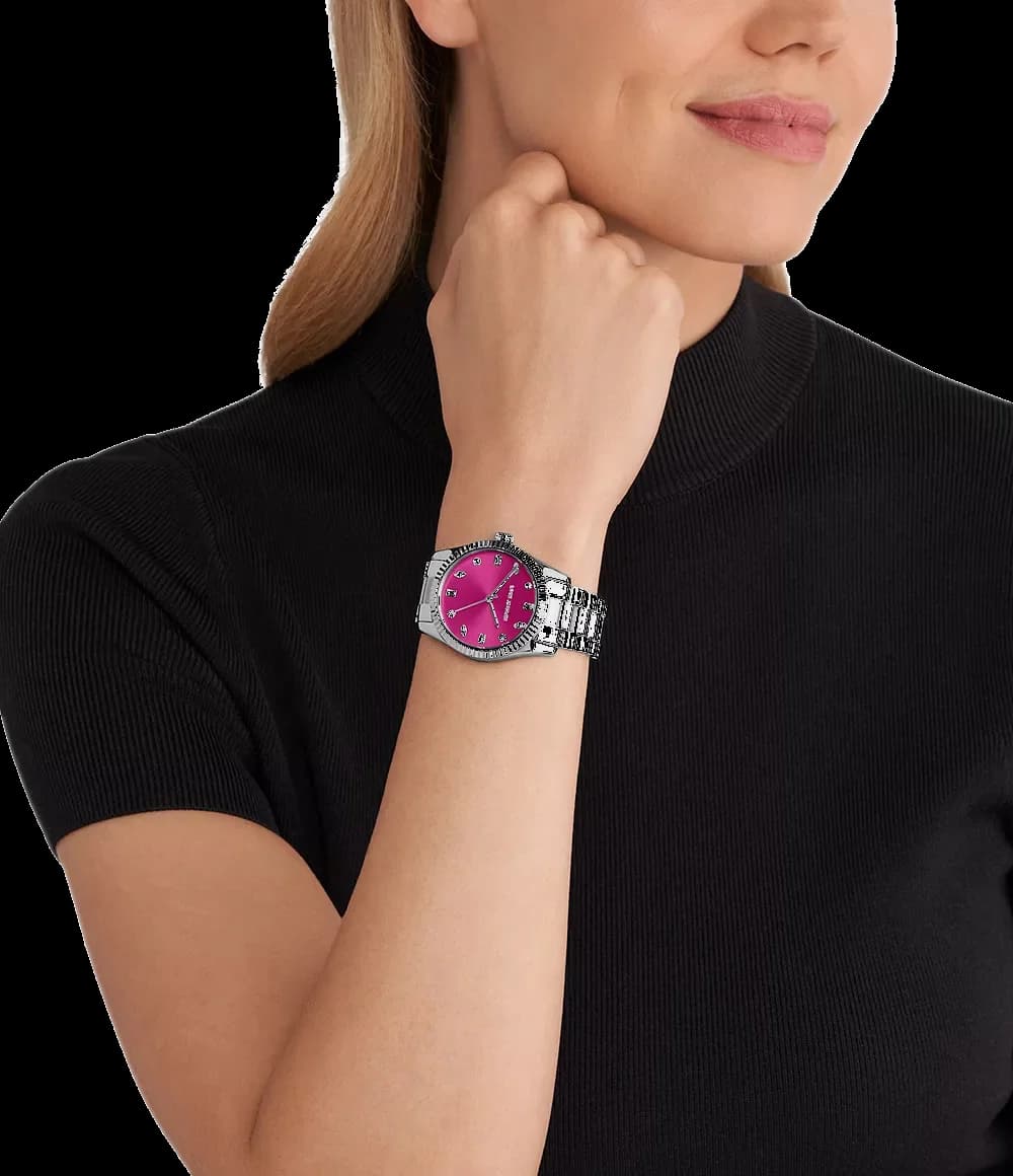 Visage cadran Michael Kors MK7443 dévoile index baguette appliqués et aiguilles bâton, date à 3h sur fond rose soleillé