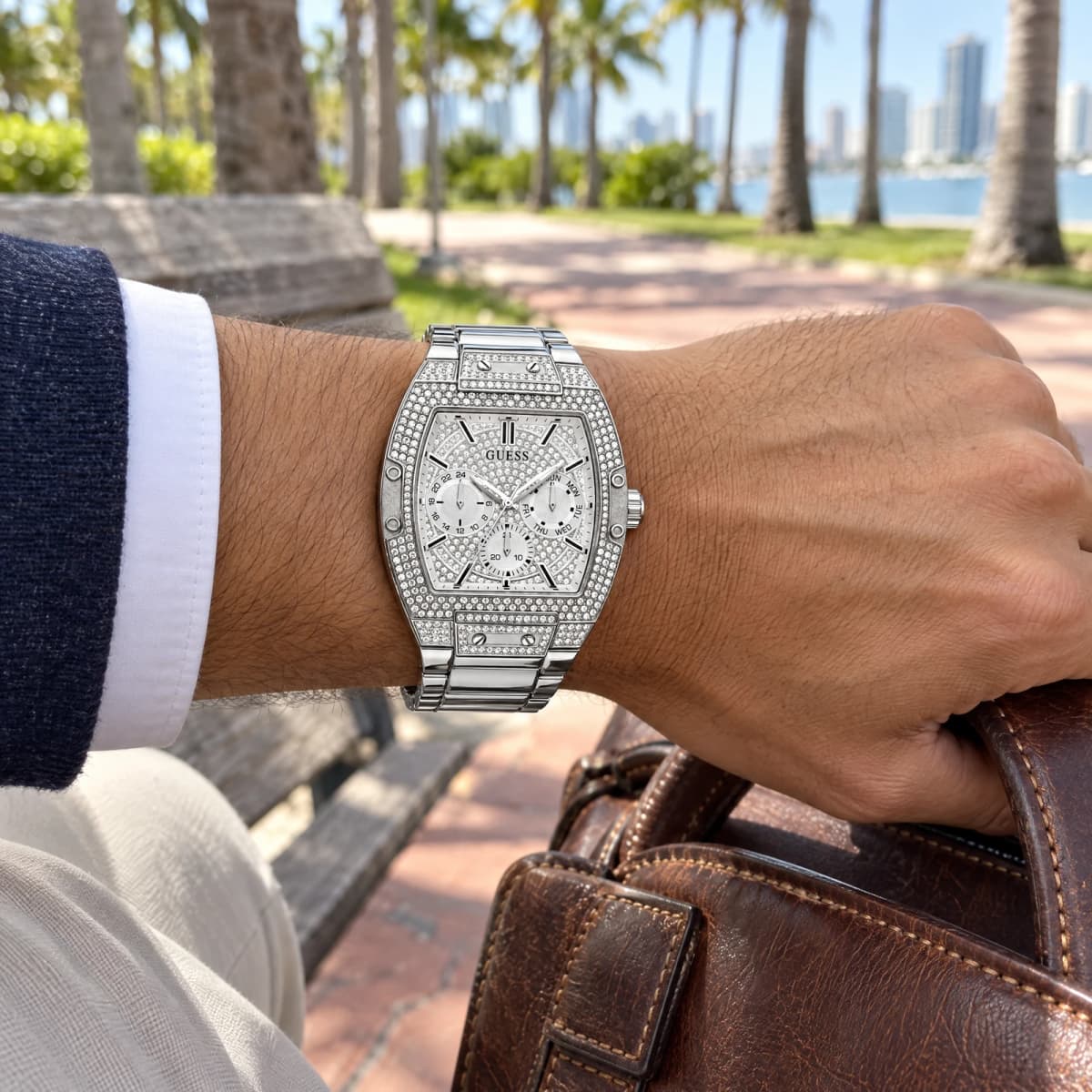 Montre Guess GW0094G1 Tonneau 43mm Micropavée de Cristaux au poignet d'un mannequin, banc de parc à Miami