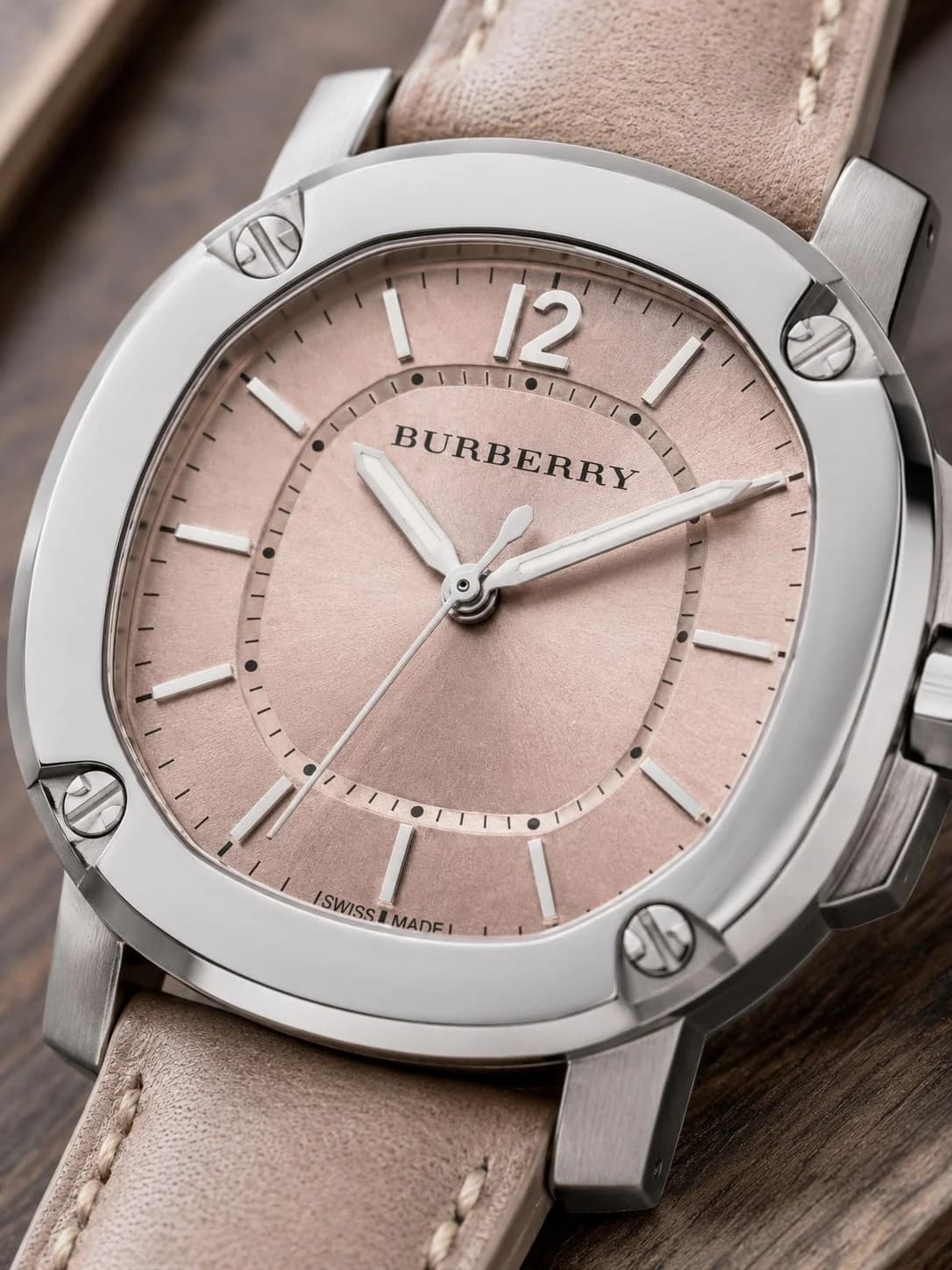 Visage cadran Burberry BBY1700 dévoile guichet date à 3h et logo Burberry sous 12h sur fond beige soleillé